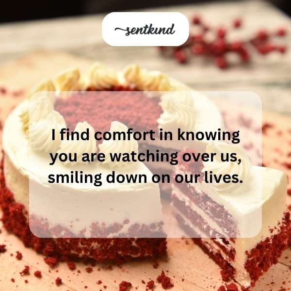 A person is smiling, holding a brightly lit birthday cake.