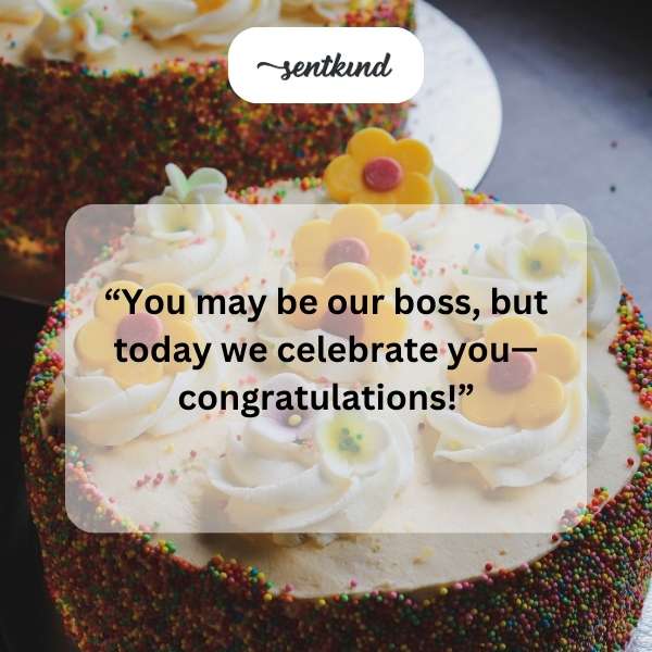 A birthday cake with candles sits beside a glass of champagne.